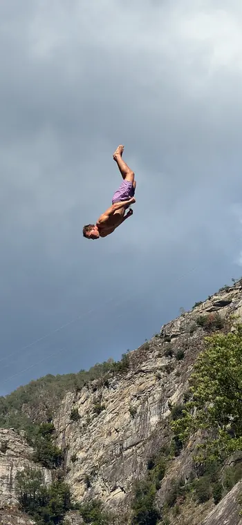 Salto beim Klippenspringen vor einer Felswand