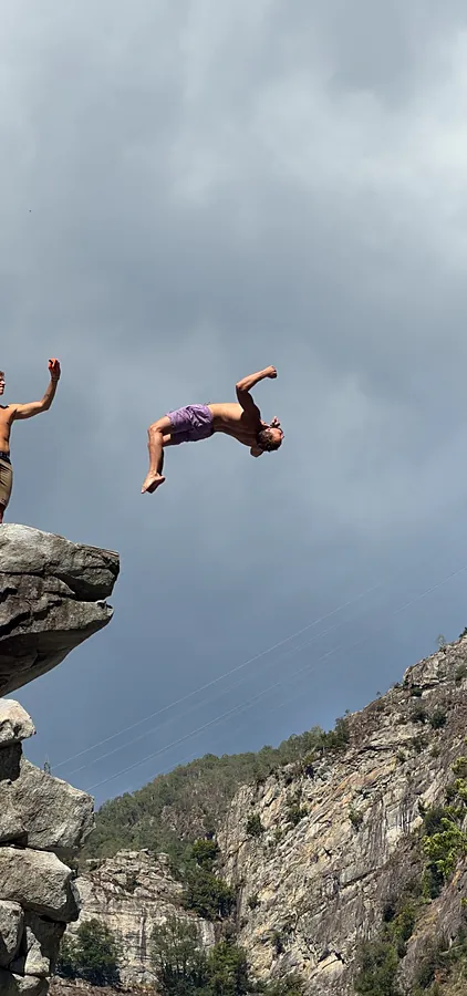 Backflip von einer Klippe vor Gewitterhimmel im Tessin