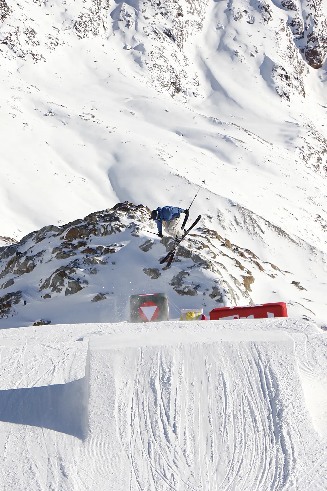 Sprung über einen Kicker im Snowpark vor Gletscherkulisse