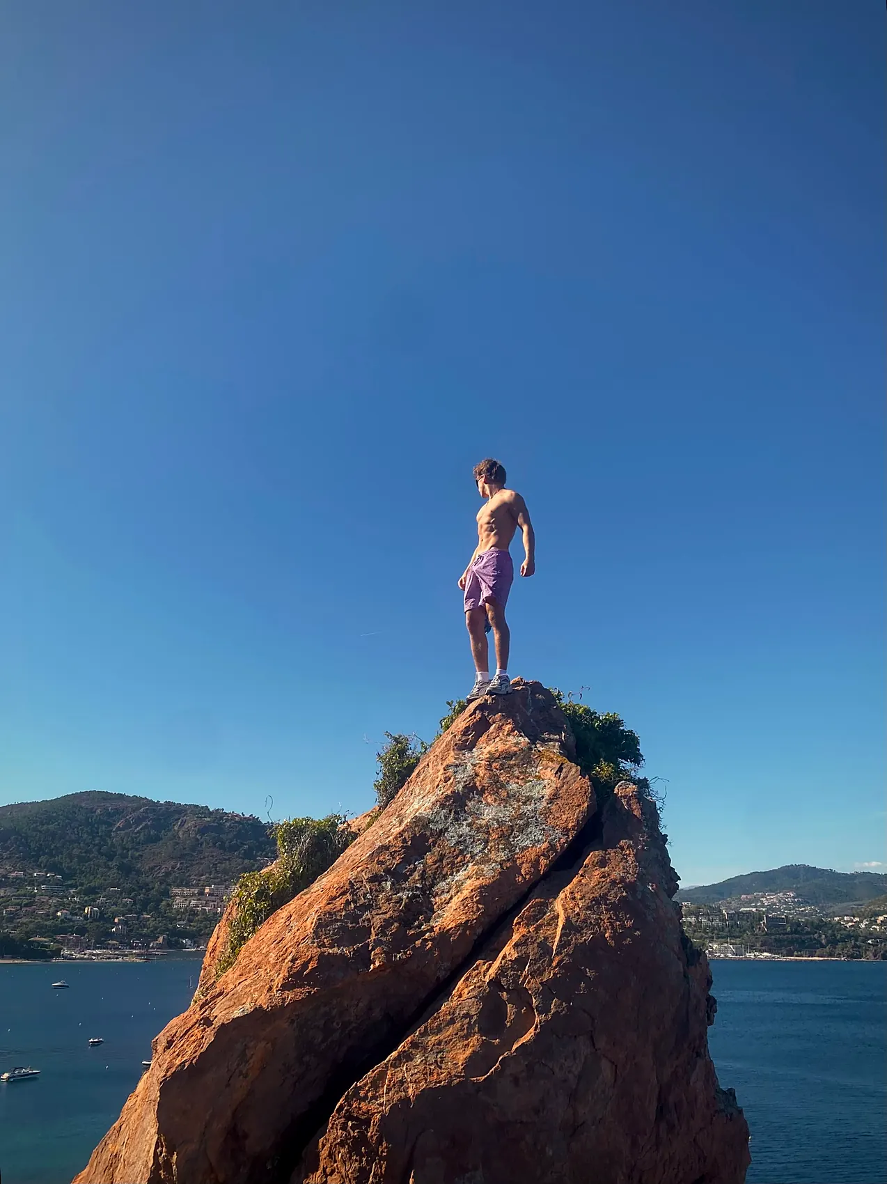 Clemens auf der Spitze eines roten Felsens über dem Meer